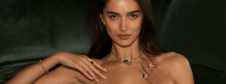 Close up of model neck wearing emerald necklace